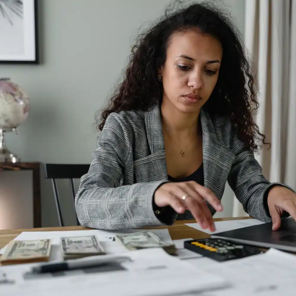 Payroll professional reviewing employee pay records, deductions and payroll reports in an office.